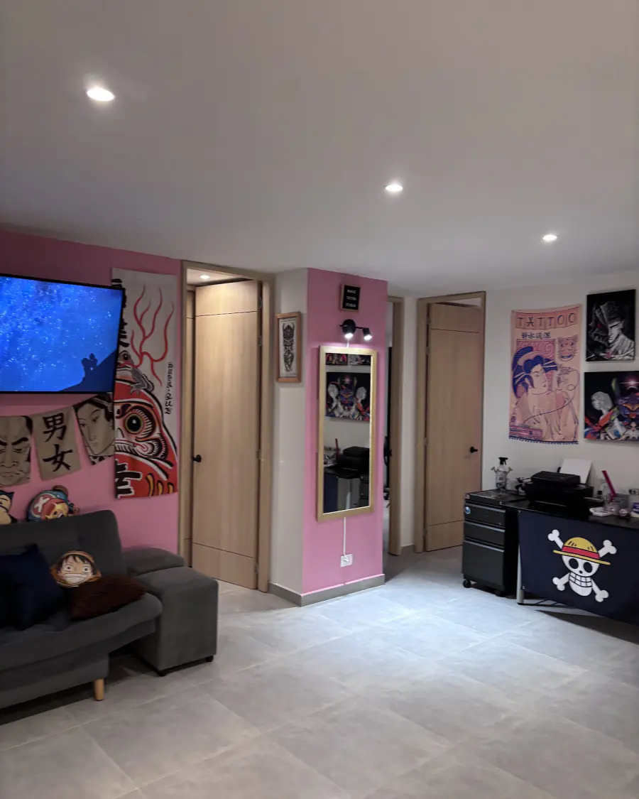 Sala de espera del estudio con paredes rosadas, sofá y arte japonés